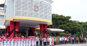 Tengah Kemeja Kaos Putih PJ Bupati Bombana pada saat menjadi Pembina Upacara di Depan Halaman Kantornya. Kiri Koramil Rumbia/mewakili, Kapolres Bombana, Ibu Bupati , Kader PKK Kabupaten para Kadis Ibu PKK lainya.
