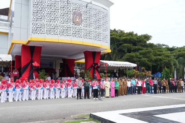Tengah Kemeja Kaos Putih PJ Bupati Bombana pada saat menjadi Pembina Upacara di Depan Halaman Kantornya. Kiri Koramil Rumbia/mewakili, Kapolres Bombana, Ibu Bupati , Kader PKK Kabupaten para Kadis Ibu PKK lainya.